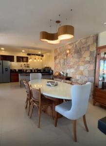 una cucina e una sala da pranzo con tavolo e sedie di Casa farol do itaqui a Luis Correia