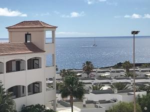 un edificio con vistas al océano y a un barco en Atlantic sunset studio, en Costa del Silencio