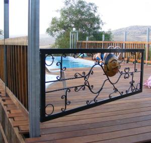 a gate on a deck with a swimming pool at wooden Edge Of The Village in Ma'ale Gamla