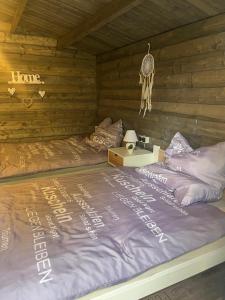 a bed in a log cabin with a sign that reads love at Forsthäuschen am Ponyhof in Wonsheim