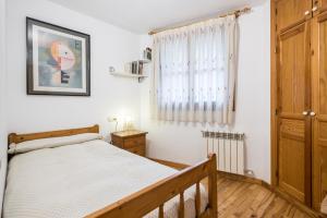 a bedroom with a bed and a window at Apartamento La Benasquita in Benasque