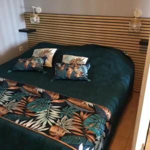 una cama con dos almohadas encima en studio Au Paradis vue mer dans village de vacances à Saint Anne, en Courcelles Sucrerie