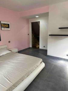 a bedroom with a white bed and a pink wall at La Maison Villageoise in Baix