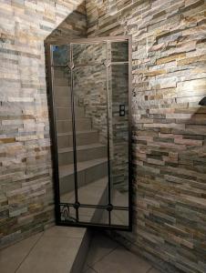 a glass elevator with stairs in a brick wall at La Maison Villageoise in Baix