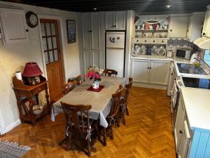 a kitchen with a table and chairs in a kitchen at The Burren Coach House in Bealaclugga