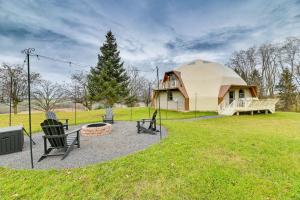 a yurt with chairs and a fire pit in a yard at The Dome' - Spacious Retreat Near Finger Lakes! in Penn Yan