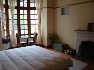 a bedroom with a bed and a table and a window at Hotel Boutique El Consulado in La Paz