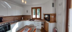 a kitchen with white cabinets and a sink and a window at Casa del Fattore in Osimo