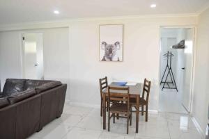 a living room with a couch and a table and chairs at ENTIRE WATERFRONT UNIT free WIFI in Dora Creek
