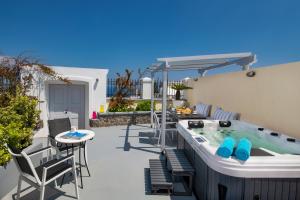 Un patio con jacuzzi y una mesa y sillas. en Day One Fira Mansion, en Fira