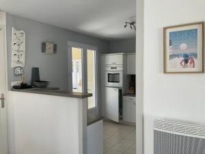 a kitchen with white appliances and a counter top at Maison bercée par le bruit de la mer île de ré in Sainte-Marie-de-Ré