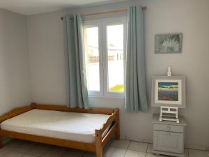 a bedroom with a bed and a window at Maison bercée par le bruit de la mer île de ré in Sainte-Marie-de-Ré