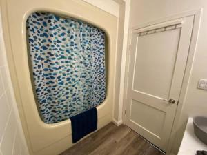 a bathroom with a door with a glass wall at Westlake Cottages - Tulip Tree in Wellington