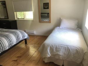 a bedroom with a bed and a mirror on the wall at Westlake Cottages - Tulip Tree in Wellington