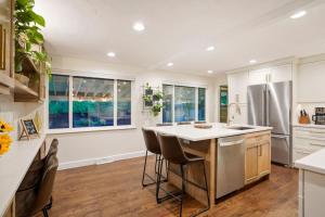 eine Küche mit weißen Schränken und eine Kücheninsel mit Barhockern in der Unterkunft BRAND NEW Classic Fire Pit 2 Kings Pet Friendly in Arvada + 27 Fotos