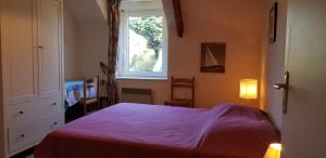a bedroom with a large bed with a window at Gite Les Oyats in Cancale