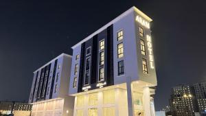 un palazzo alto con luci accese di notte di فندق آرام النسيم a Ash Shishah