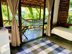 パラチにあるEco Lodge in nature -10 min to Paraty centerlのハンモックとポーチが見える寝室