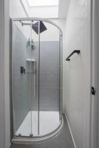una ducha con puerta de cristal en un baño en Grand Urban 4BR Luxe Loft in Griffintown, en Montreal
