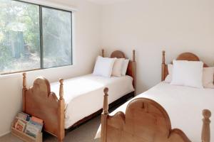 two beds in a room with a window at Banksia House Cape Paterson in Cape Paterson