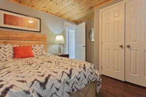 een slaapkamer met een groot bed en een houten plafond bij Westlake Consecon Cottage in Wellington