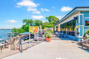 un bâtiment avec des chaises et des parasols au bord de l'eau dans l'établissement Sunset Shores at the Stillwater in Bridges Bay Resort, à Arnolds Park