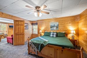 Un dormitorio con una cama y un ventilador de techo. en Starry Mountain View- Hot Tub - Pool Table - Prime Location, en Pigeon Forge