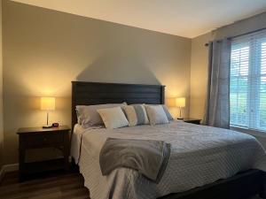 a bedroom with a large bed with two lamps and a window at Golf Front Longleaf Condo2BR 2BA in Southern Pines
