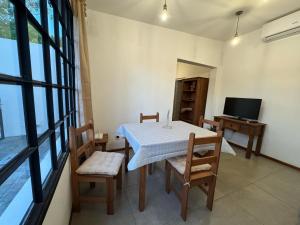 una sala da pranzo con tavolo, sedie e televisione di La Casita a Durazno