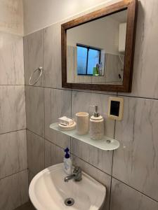 un bagno con lavandino e specchio di La Casita a Durazno