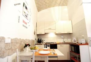 a kitchen with white cabinets and a table and chairs at Little House Roma in Rome +10 photos