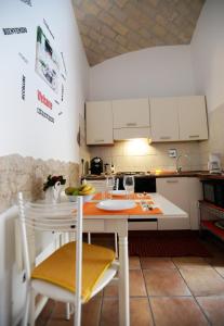a kitchen with white cabinets and a table and chairs at Little House Roma in Rome