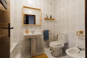 a bathroom with a sink and a toilet and a mirror at Casa do Sargaço Moledo in Moledo +9 photos