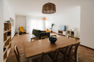 a living room with a wooden table and chairs at Casa do Sargaço Moledo in Moledo