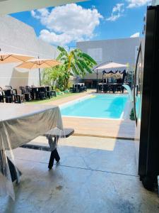 a pool with tables and chairs and umbrellas at Espaço Varanda in Sao Paulo