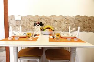 ローマにあるLittle House Romaの椅子2脚と花の白いテーブル