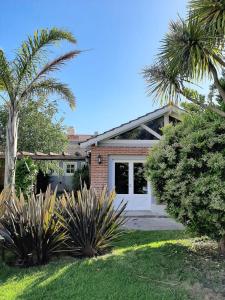 a house with a white garage and palm trees at Costa Remanso in Miramar