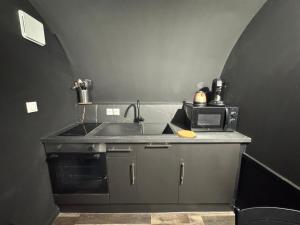 a kitchen with a sink and a microwave at CinemaRoom - Netflix -Hyper Centre in Arras