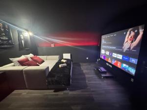 a living room with a couch and a flat screen tv at CinemaRoom - Netflix -Hyper Centre in Arras