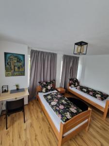 a room with two beds and a desk and a bed at Kleine Zimmer in Gästehaus in Feldkirch