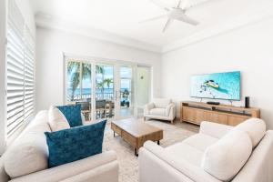 un salon avec deux canapés blancs et une télévision dans l'établissement South Bay Beach Club #1 - 2 Bedroom 2 Bathroom Unit, à Dog City