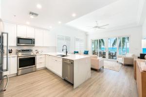 une cuisine avec des armoires blanches et un salon dans l'établissement South Bay Beach Club #1 - 2 Bedroom 2 Bathroom Unit, à Dog City