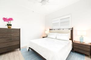 une chambre blanche avec un lit et une commode dans l'établissement South Bay Beach Club #1 - 2 Bedroom 2 Bathroom Unit, à Dog City
