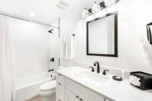 une salle de bain blanche avec un lavabo et un miroir dans l'établissement South Bay Beach Club #1 - 2 Bedroom 2 Bathroom Unit, à Dog City 4 autres photos