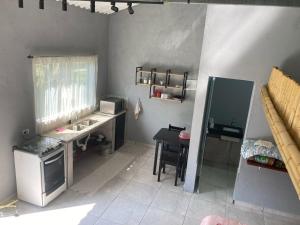 a small kitchen with a sink and a table at Chalé 2 - Lateral in São Bernardo do Campo