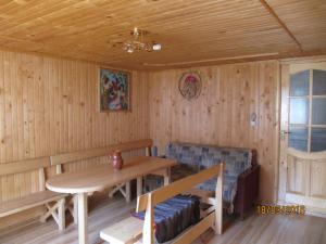 a wooden room with a table and a bench and a couch at Sadiba Pid Skeleyu in Putyla