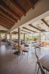 a restaurant with wooden tables and chairs and windows at Costa Remanso in Miramar