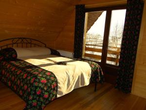 a bedroom with a bed and a large window at Chata Pod Grapom in Czarna Góra