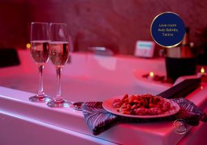 two wine glasses and a plate of food on a table at L'Ecrin d'Albi - Love Room - 1 chambre in Albi