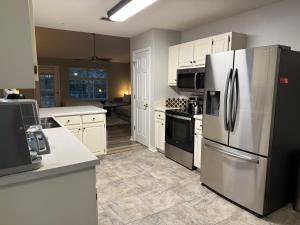 a kitchen with white cabinets and a refrigerator at The Crestview Beach House in Crestview